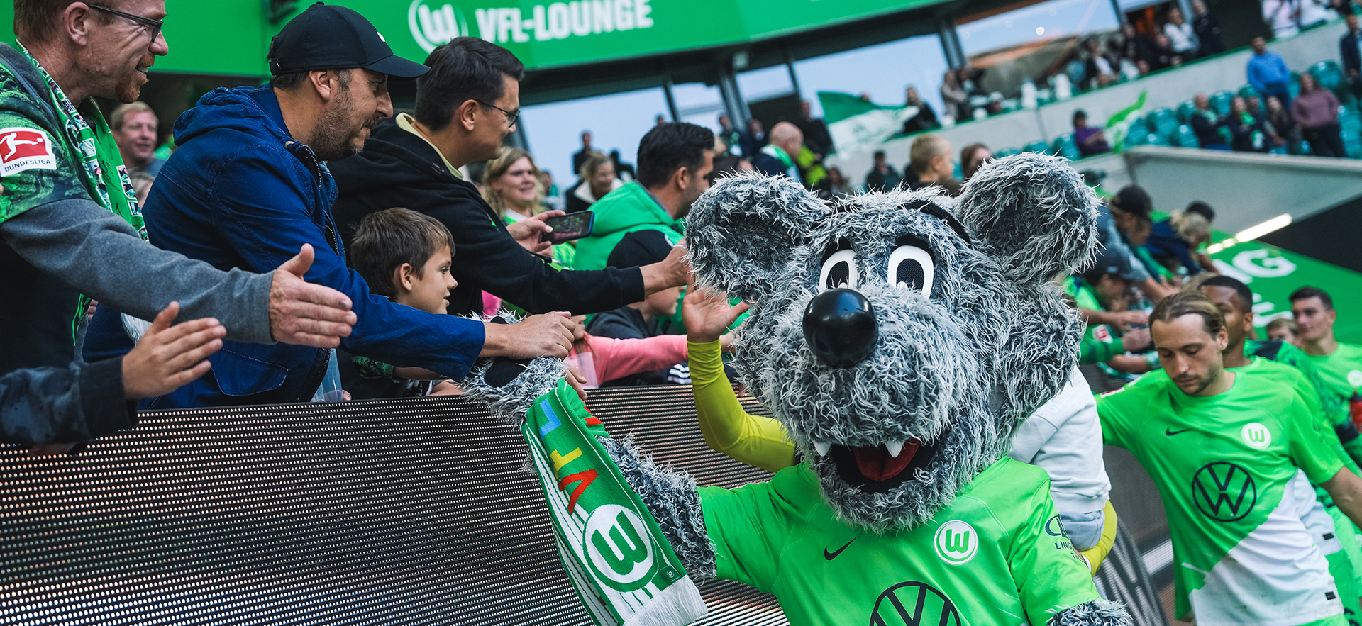 Wölfe läuft nach dem Spiel an der Tribüne vorbei und klatscht mit den Fans ab.