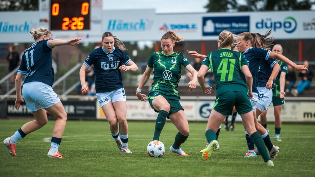 VfL-Wolfsburg-Spielerinnen und Gegenspielerinnen kämpfen um den Ball.