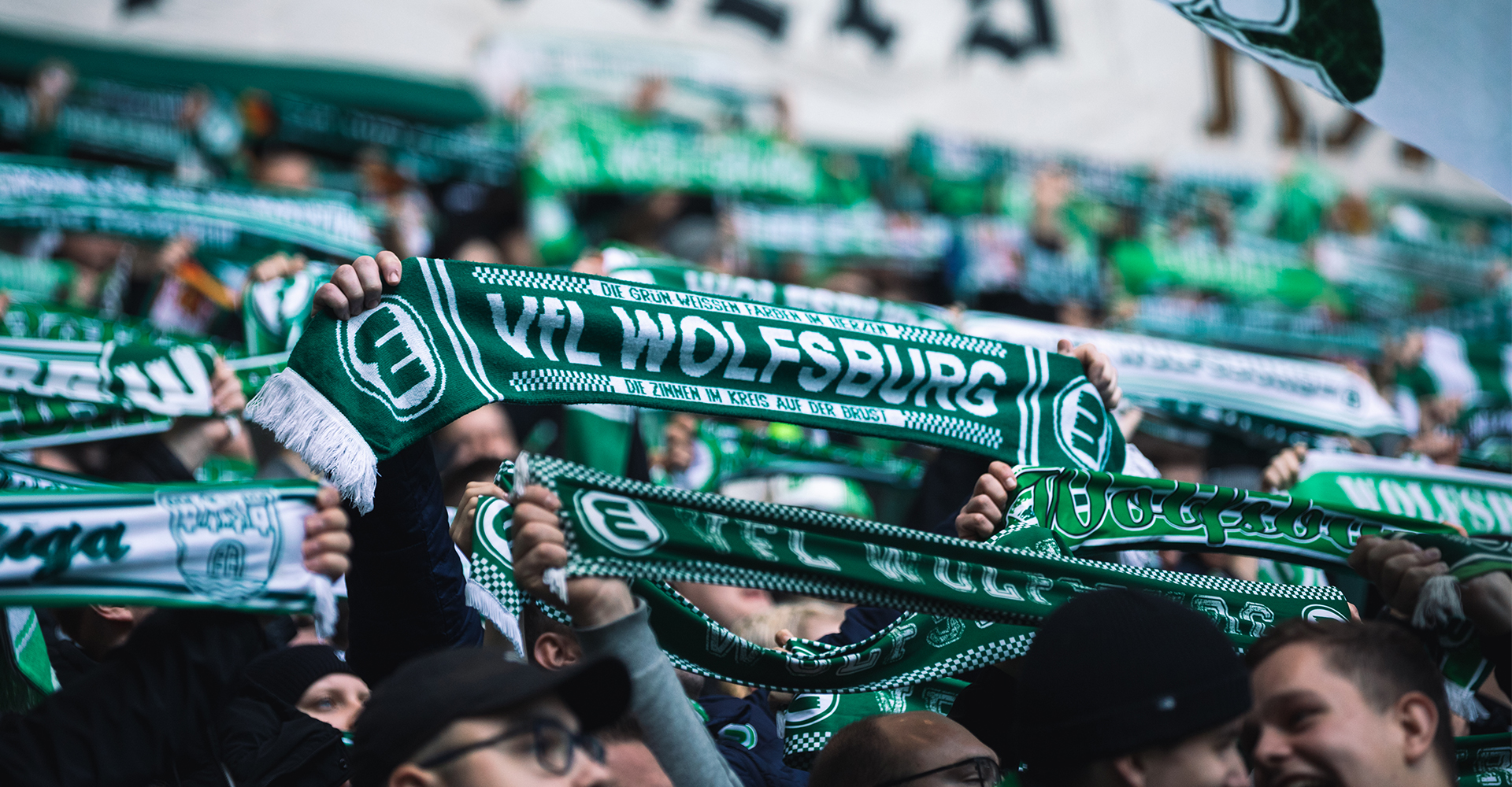 Ein Foto von VfL Fans, die alle ihren Schal hochhalten.