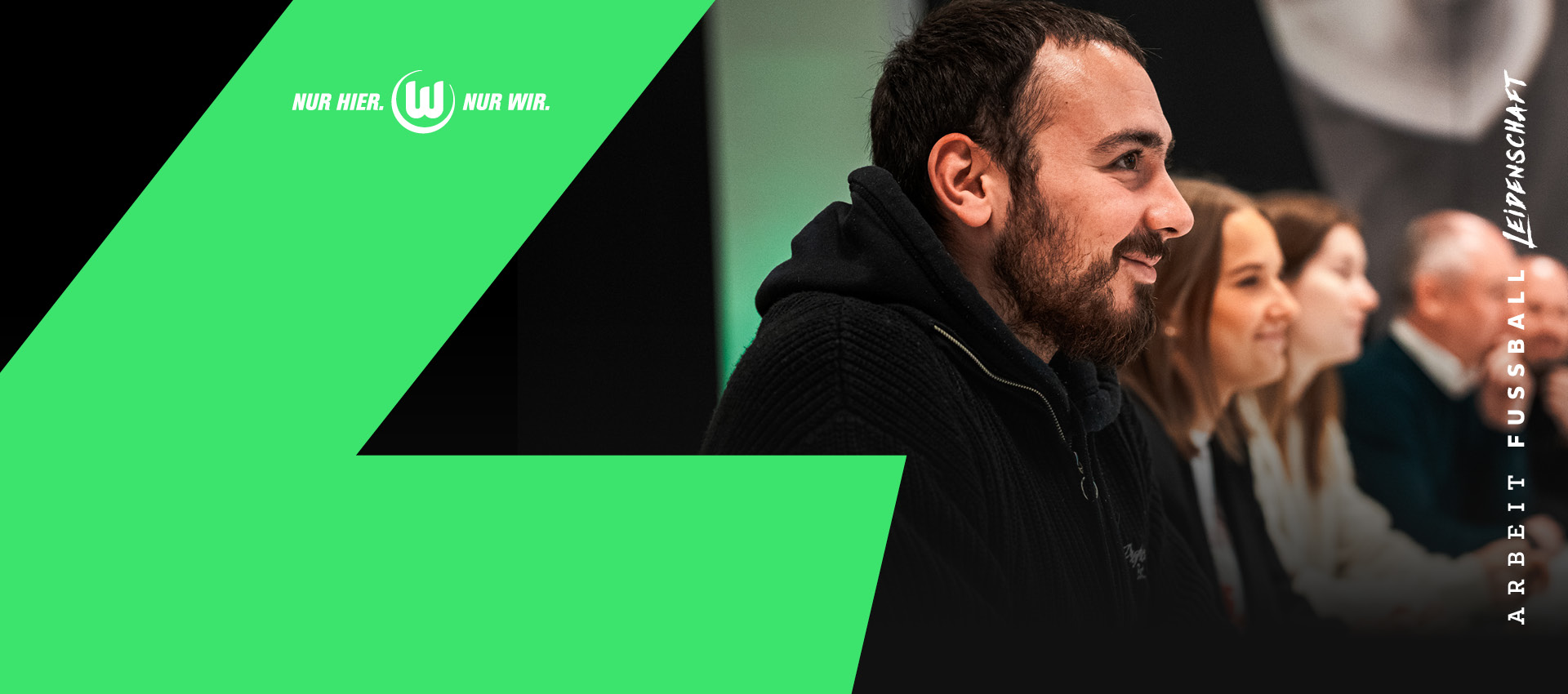 Mann mit schwarzer VfL Strickjacke vor grünem Hintergrund mit „Nur hier. Nur wir.“ Branding.