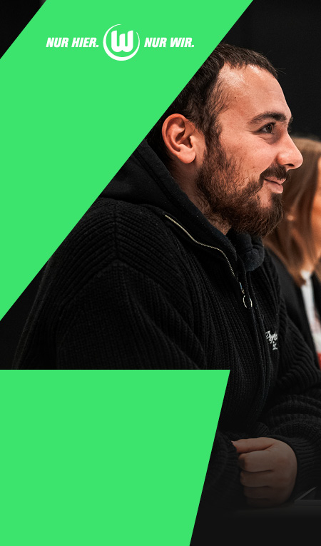 Mann mit schwarzer VfL Strickjacke vor grünem Hintergrund mit „Nur hier. Nur wir.“ Branding.