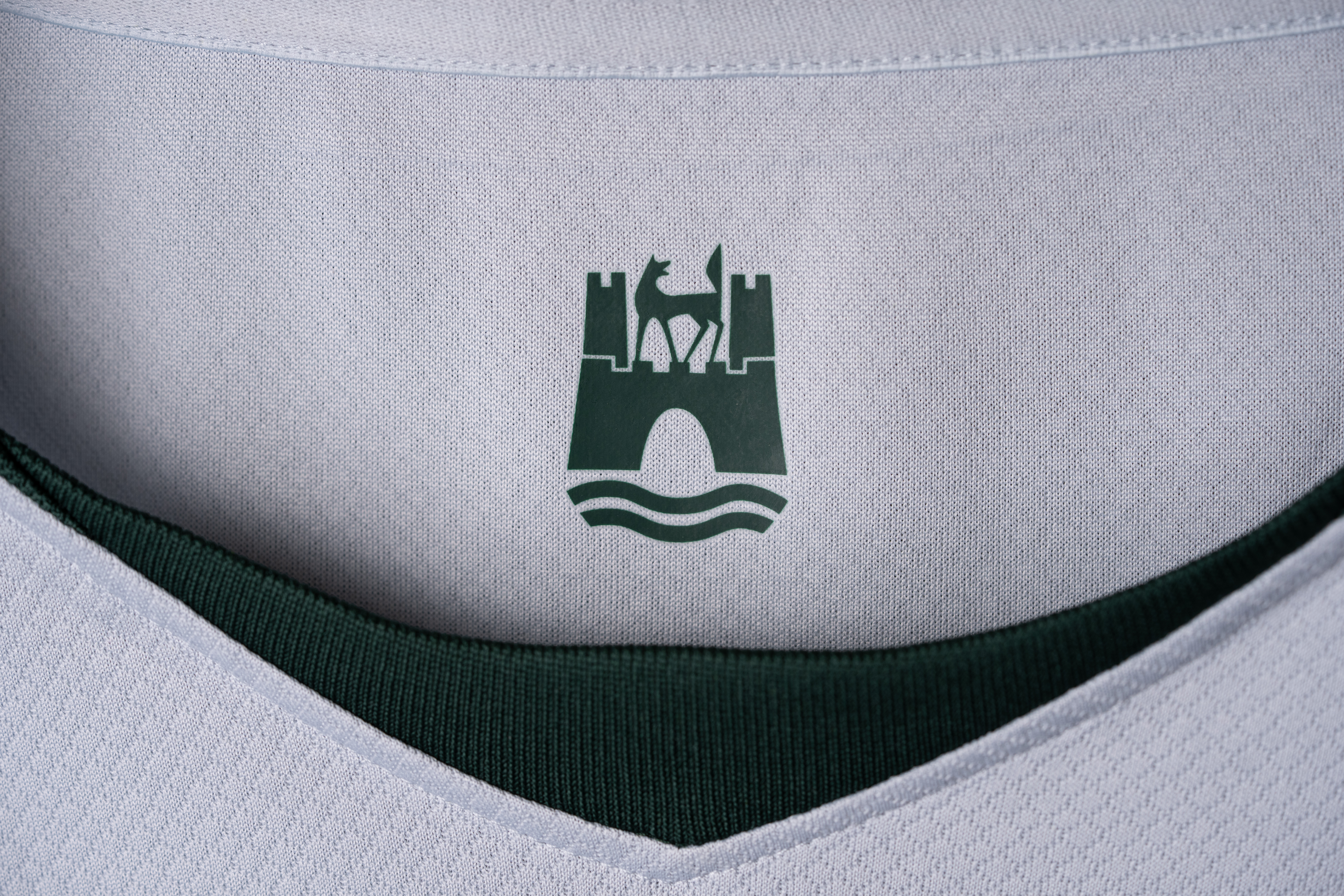 Nahaufnahme des Nackenbereichs eines VfL-Wolfsburg-Trikots mit Wolfsburg-Wappen