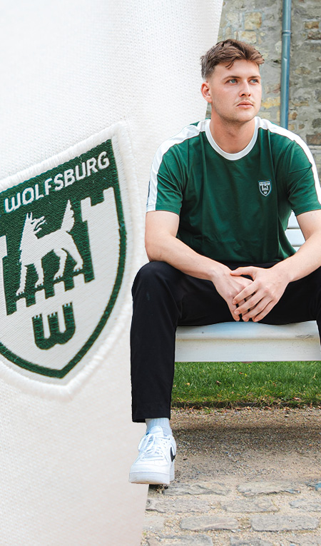 VfL-Wolfsburg-Kollektion mit grüner und weißer Kleidung sowie sichtbaren Vereinslogos.