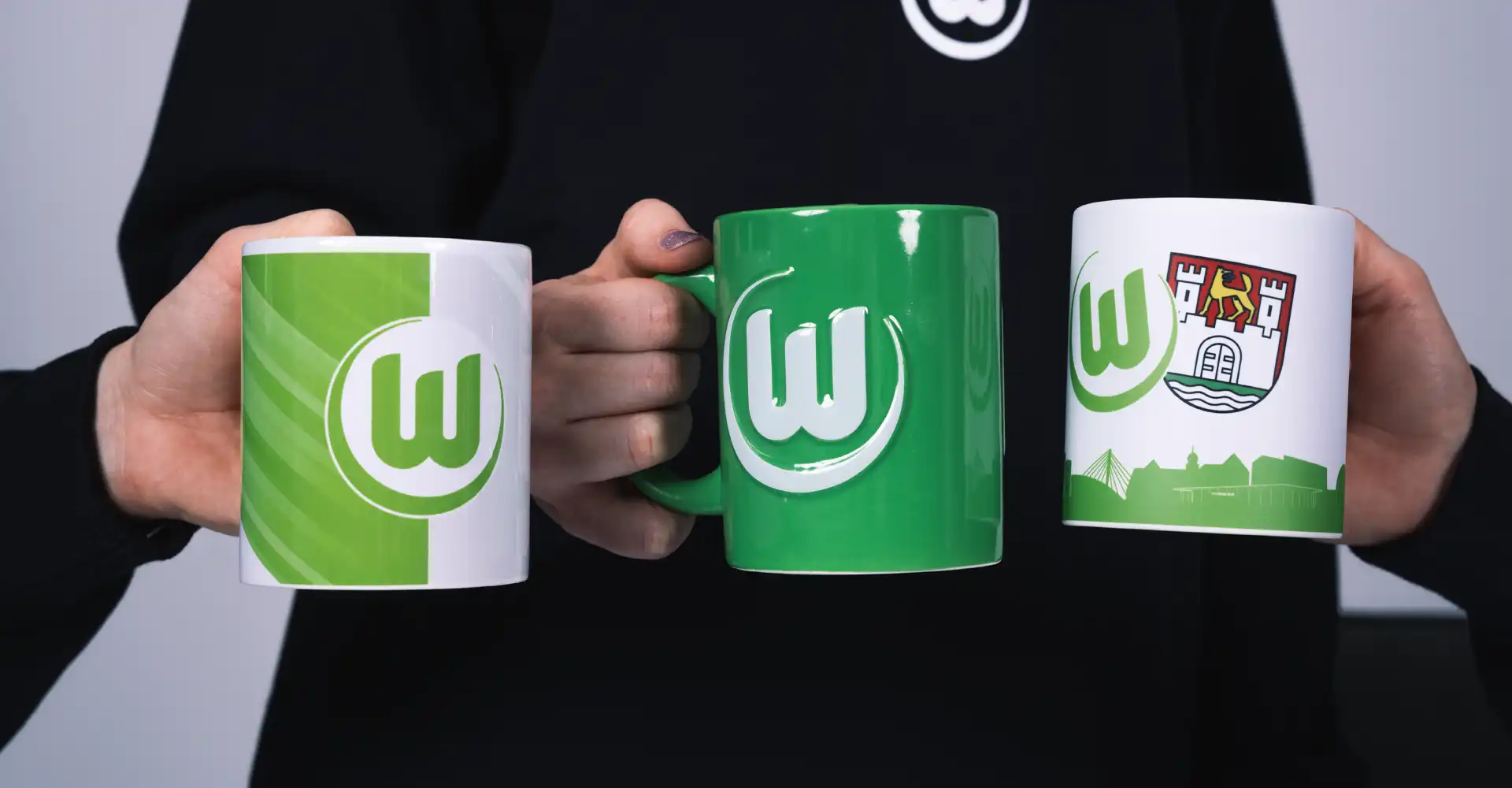 Drei VfL Tassen werden in die Kamera gehalten.